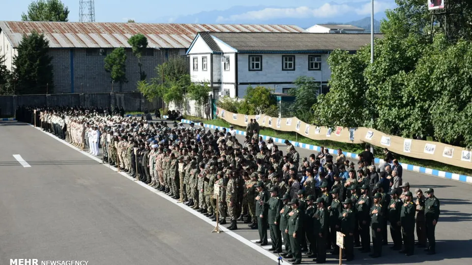 Ranks of uniformed Army, IRGC and police personnel stand in formation on a parade ground