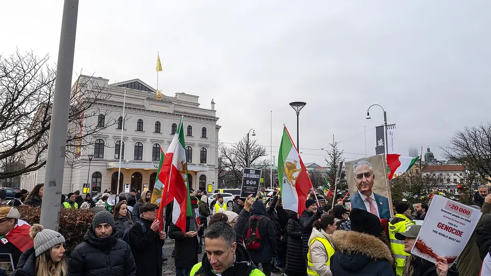 Demonstrators with Iranian flags and placards gather in a square in Gothenburg